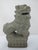 Carved stone Chinese guardian lion, or Foo Dog, featuring a stylized open mouth with ball inside and and ornate carved...