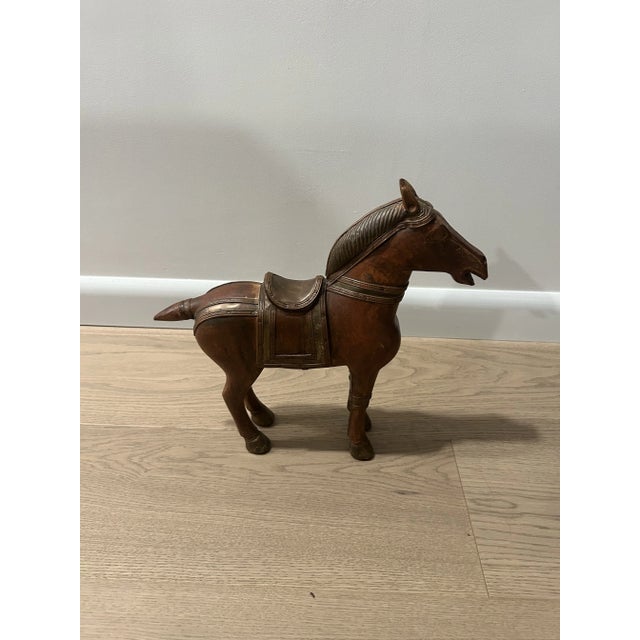 Chinese carved wooden horse figurine. Nice patina on brass accents. This is interesting decor for a table setting or...