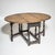 English drop-leaf table with an oval top and hinged leaves on both sides, supported by turned legs with stretchers. The...