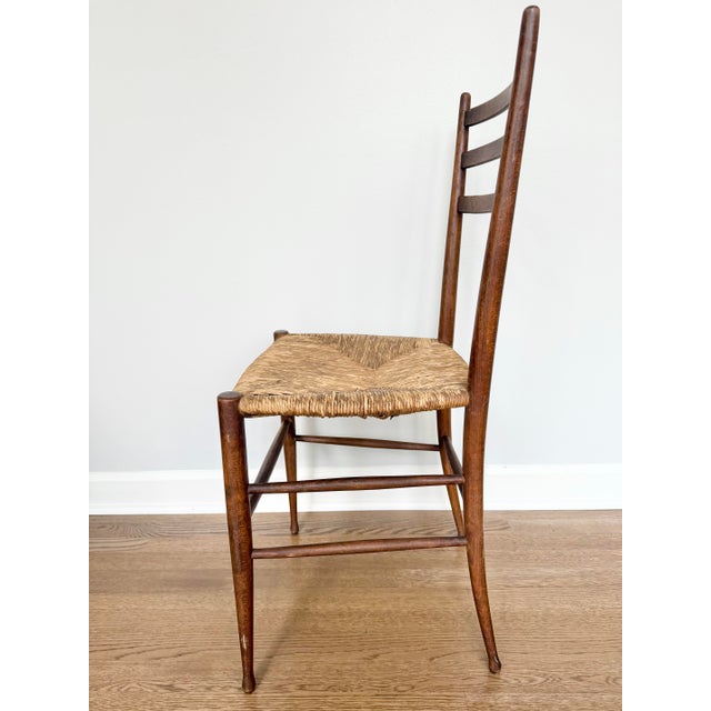 Exceptionally lightweight mid-century ladder-back chair with handwoven rush seat and elegantly tapered wood frame....
