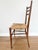 Exceptionally lightweight mid-century ladder-back chair with handwoven rush seat and elegantly tapered wood frame....