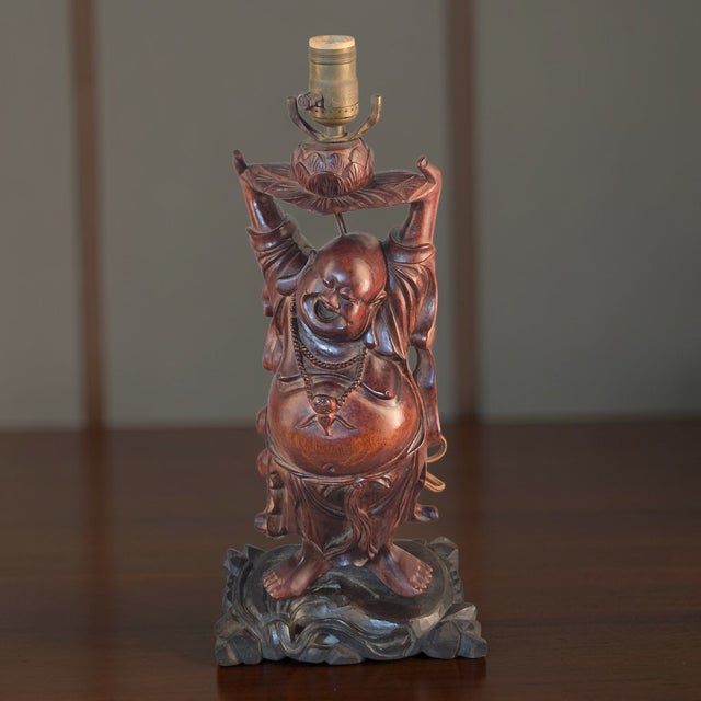 The Antique Hand Carved Hardwood Hotei Happy Joyous Buddha Arms Raised Table Lamp is a unique and decorative piece perfect...