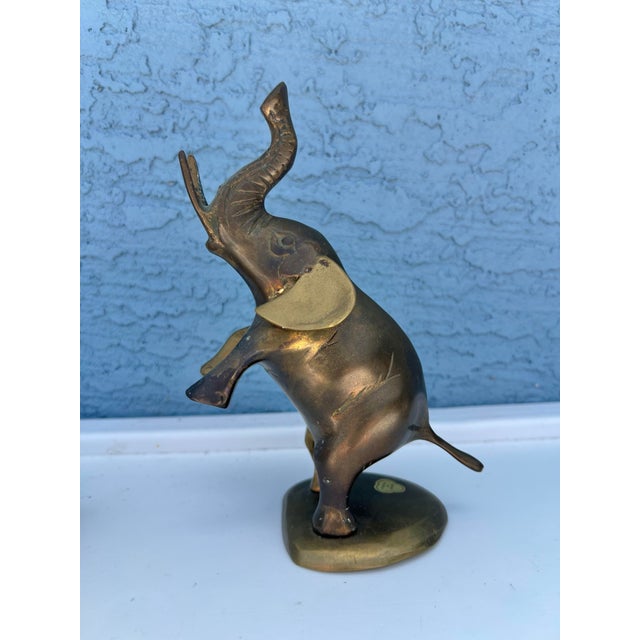 Mid 20th Century Brass figure. Elephant standing on 2 legs with trunk up in air. Sticker on bottom made in Korea