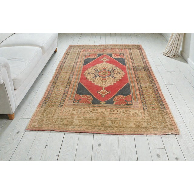 This is a vintage Turkish Oushak rug from the Mid 20th Century. The piece was hand-knotted.