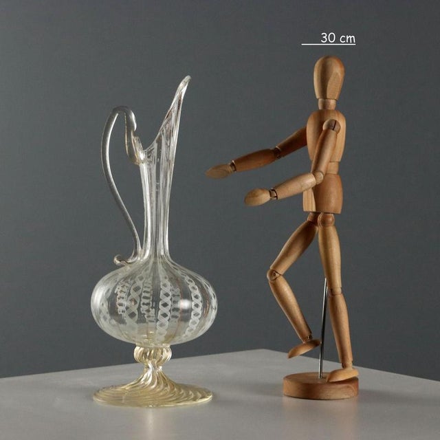 Glass globular pourer with white and gold filigree. Spiral base with gold flecks. Beveled handle and long spout. This...