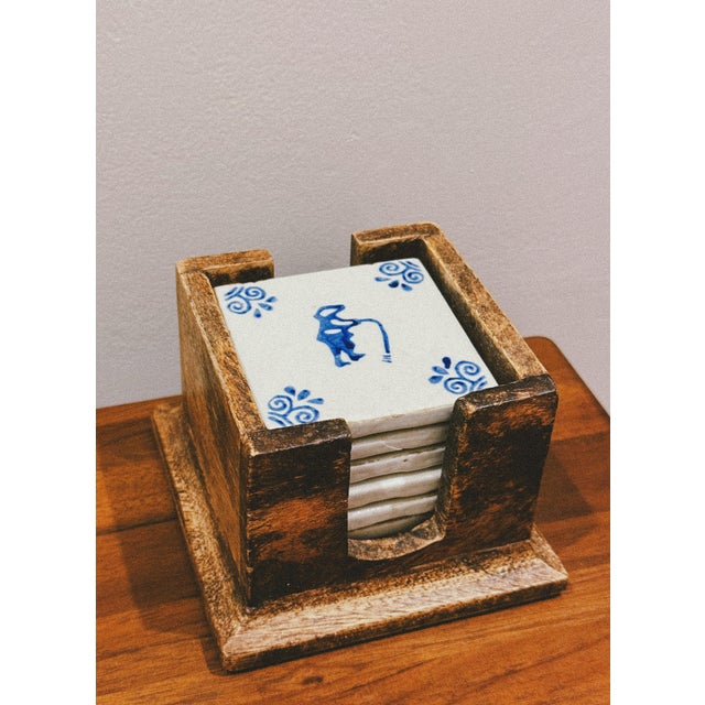 Set of hand-painted faience coasters with figurative blue decoration on a white background, inspired by rural daily...