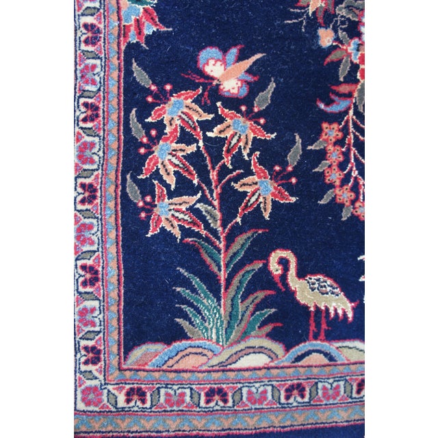 Vintage Persian Oriental vase rug featuring a field of navy blue with a large central vase arrangment of flowers with...