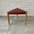 Scandinavian mid-century stool made from solid oak with a triangular seat upholstered in red leather. Decorative brass...