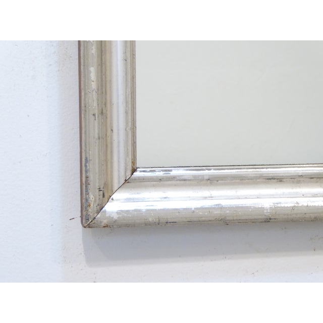 This weathered silver mirror measures 23.5"H x 17.5"W/