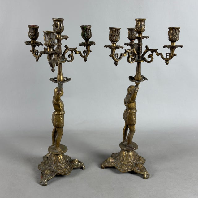 An elegant and scenic pair of finely crafted cast bronze four-light candelabras, a fine decorative piece dating to the...