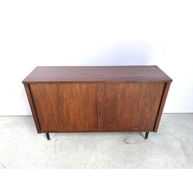 Attractive mid century cabinet with two sliding tambour doors. Beautiful teak wood, very well crafted tambour doors and 5...
