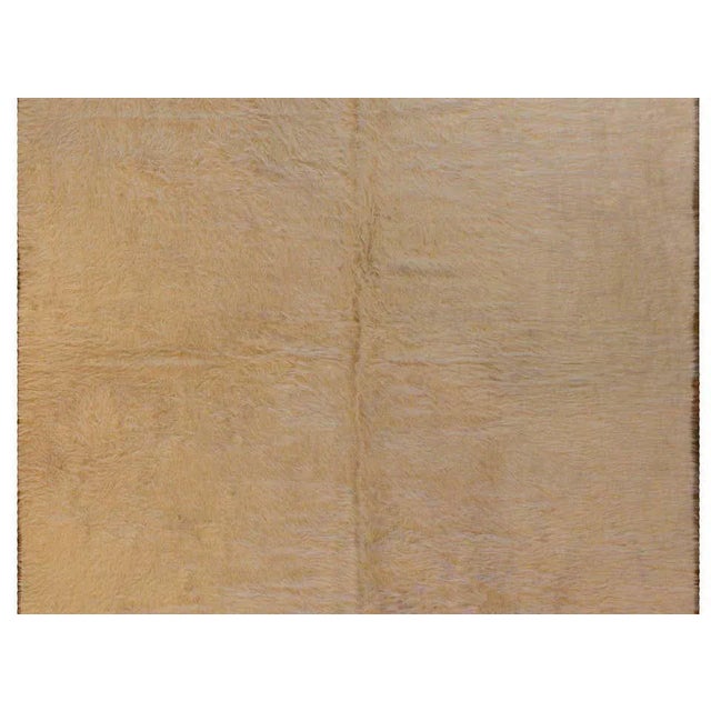 A lush mid-20th century Turkish Siirt rug with a cream colored long wool field on a flat-woven ground.