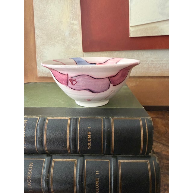 Vintage wheel-thrown studio pottery bowl featuring a soft, creamy ground with abstract hand-painted washes in blush pink...