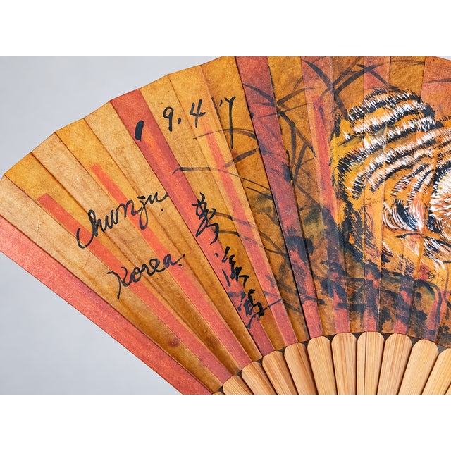 Vintage Korean hand-painted tiger folding fan, dated 1941, featuring a dramatic tiger design on warm-toned paper with...