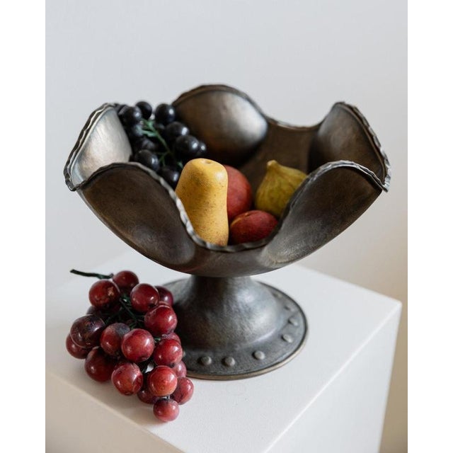 This vintage silver-plated copper bowl from the 1950s is a beautifully handcrafted piece featuring an elegant footed base...