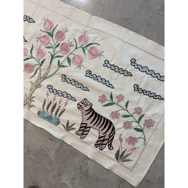 Hand-embroidered Suzani table runner from Uzbekistan — three striped tigers beneath a pomegranate tree with blue cloud...