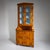 Biedermeier corner cabinet veneered in birch, featuring a two-door lower section and a glazed two-door upper section...