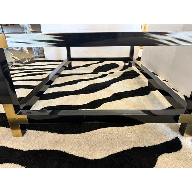 Glamorous modern designer coffee table having a sensational mix of black faux horn, gold brass accents and inset glass...
