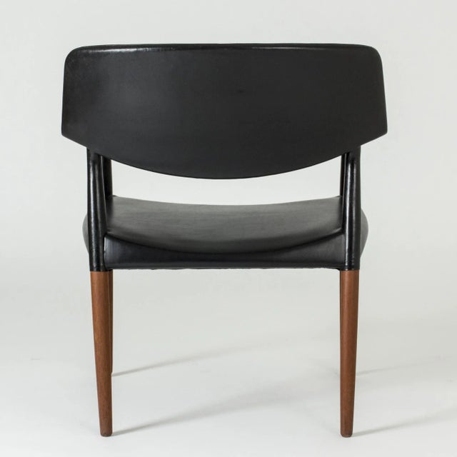 Cool armchair by Aksel Bender Madsen and Ejner Larsen, made from teak and dressed with black leather. High comfort. This...