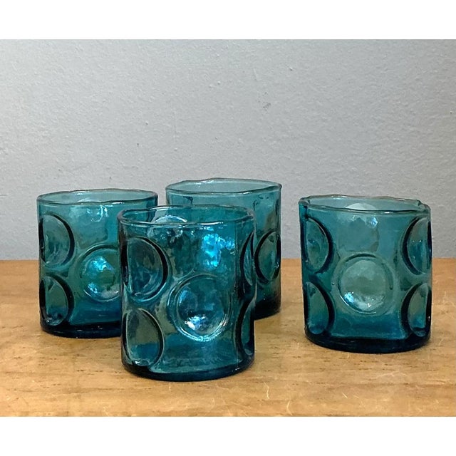 This set of four vintage glass shot glasses is a study in saturated color and sculptural texture. Each glass is a short,...