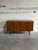 This minimalist low-profile credenza features a streamlined rectangular frame supported by dark tapered legs. The double...