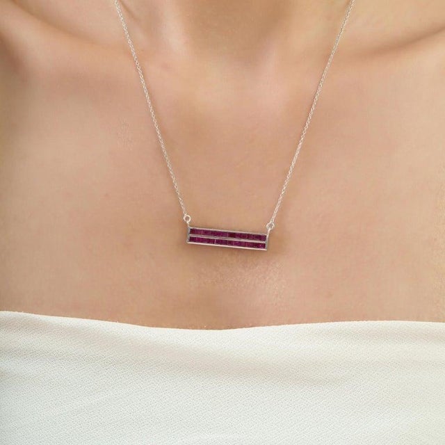 Crafted in 925 sterling silver, this elegant bar pendant showcases 2.81 carats of square-cut natural rubies in a sleek...