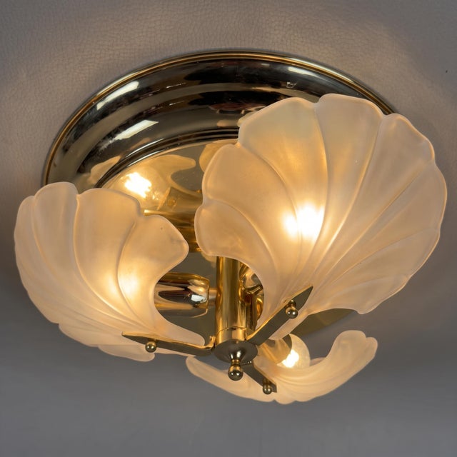 A refined and dramatic modernist ceiling or wall light featuring a composition of three shaped frosted glass diffusers on...