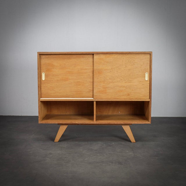 A clean and functional sideboard by czech designer jiří jiroutek, known for his elegant storage furniture and refined use...