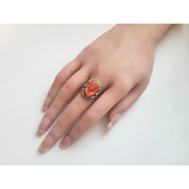 A charming Victorian ring crafted in 14kt yellow gold, centered with a finely carved genuine Mediterranean coral cameo...