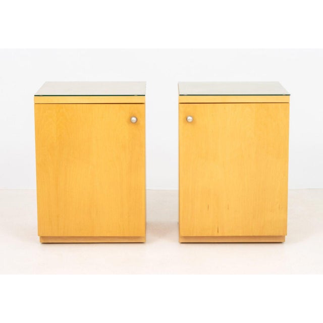 Pair of Art Deco Style Blonde Wood Cabinets, after Donald Deskey (American, 1894-1989), each with glass top above single...
