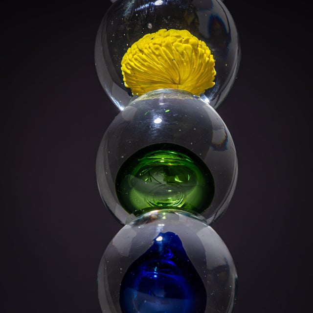 Sculptural glass column in Murano glass set on a rectangular clear glass base. Above rise progressively larger glass...