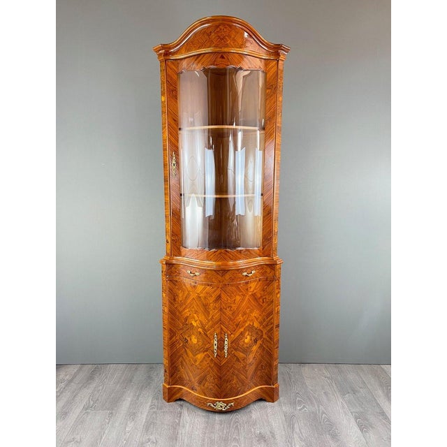 Corner marquetry display cabinet, circa 1900 An elegant corner display cabinet from the late 19th or early 20th century....