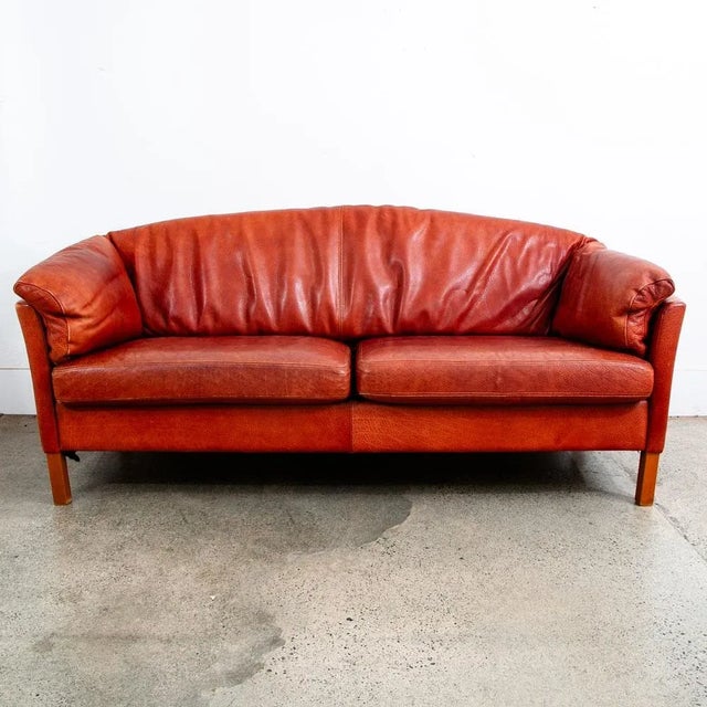 Gorgeous rust / red 3 seater sofa on wood legs. Rich and thick top grain leather throughout. Recently imported from Denmark.