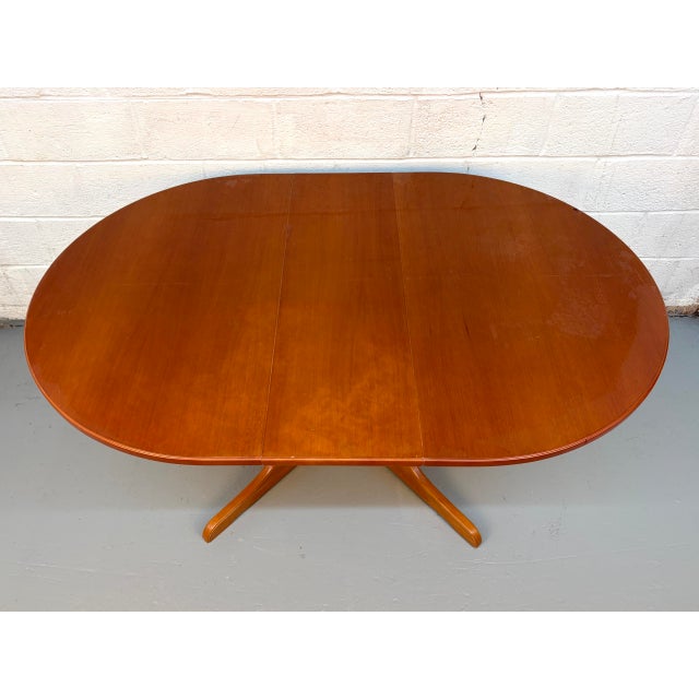 This elegant MCM Modern dining table features a rich teak grain and a versatile drop-leaf design, perfect for optimizing...