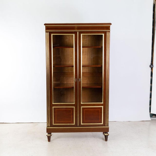 Mahogany veneer on oak. Brass banding and moldings. Four adjustable shelves. White marble top.