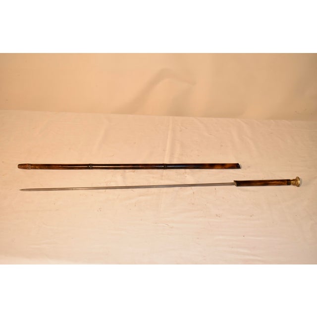 19th century sword cane from England with a metal top, which opens to reveal a snuff compartment. The can itself is made...