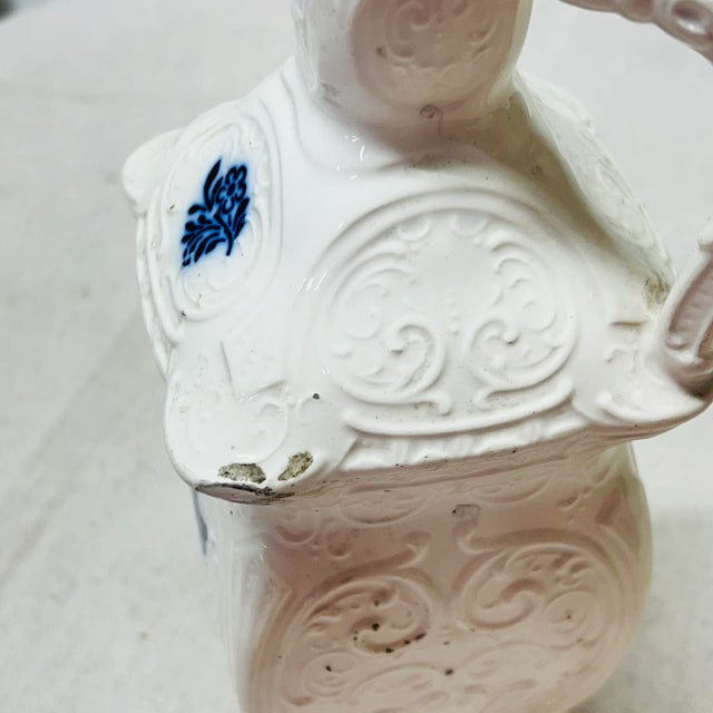 Offered here is a set of white with blue print oil and vinegar jars. Blue print on front and raised white design on all...