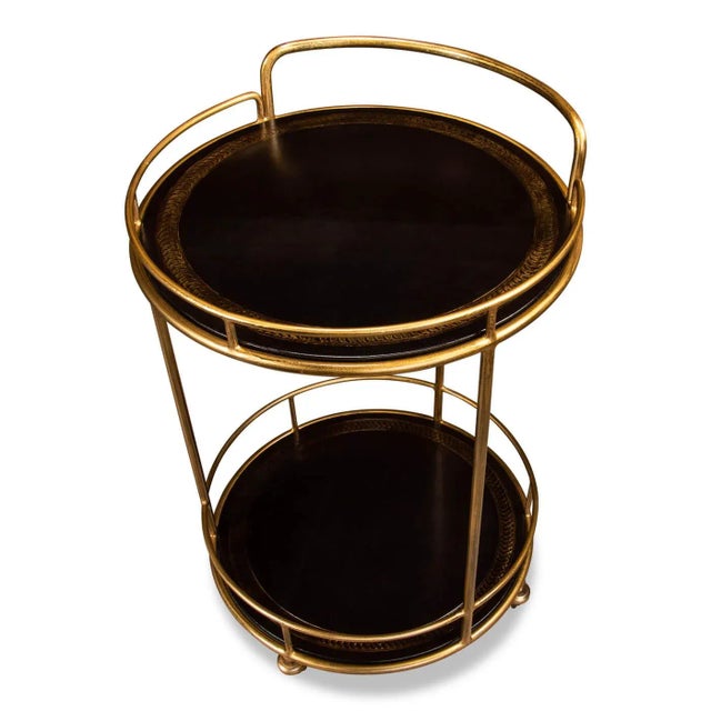 Modern iron and leather serving side table and cart. This smaller two-tiered round serving cart sits on gold casters and...