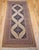 "This exceptional Malayer rug features a striking open-field design set against a warm and inviting camel hair background...