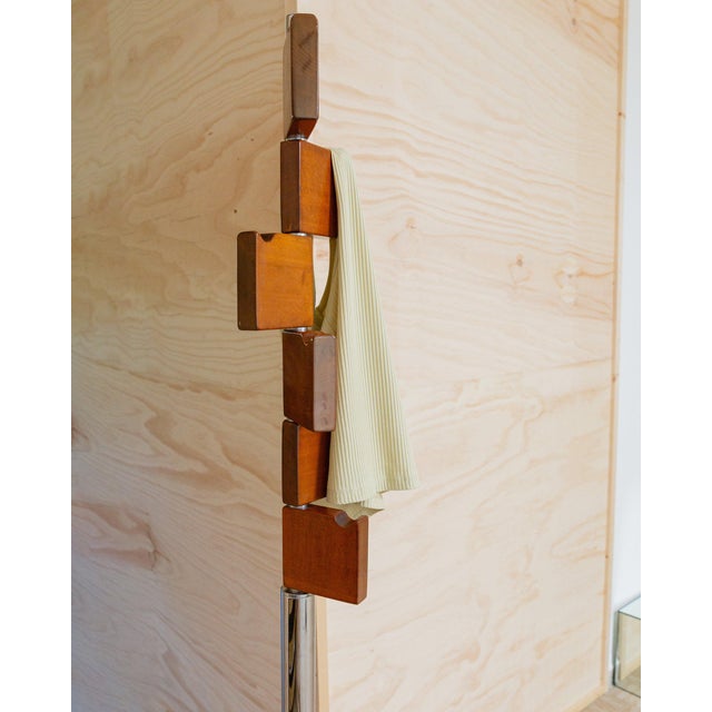 Chrome and wood come together in a mid-century design. The coat rack impresses with its swivelling wooden hooks on a...