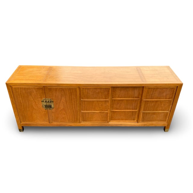 A refined vintage sideboard by Baker Furniture, executed in richly figured walnut and distinguished by its architectural...