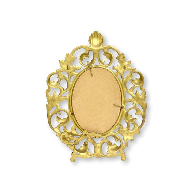 Early 20th century French brass picture frame with elaborate scrolling filigree and shell crest decoration. Substantial in...