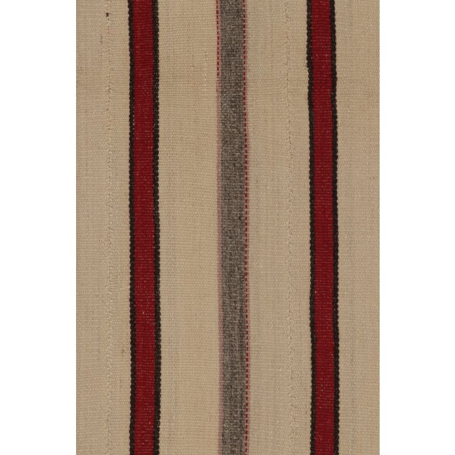Handwoven in wool, this 5x7 contemporary Rez kilim pairs an ivory field with slender red, charcoal, and taupe stripes. Its...