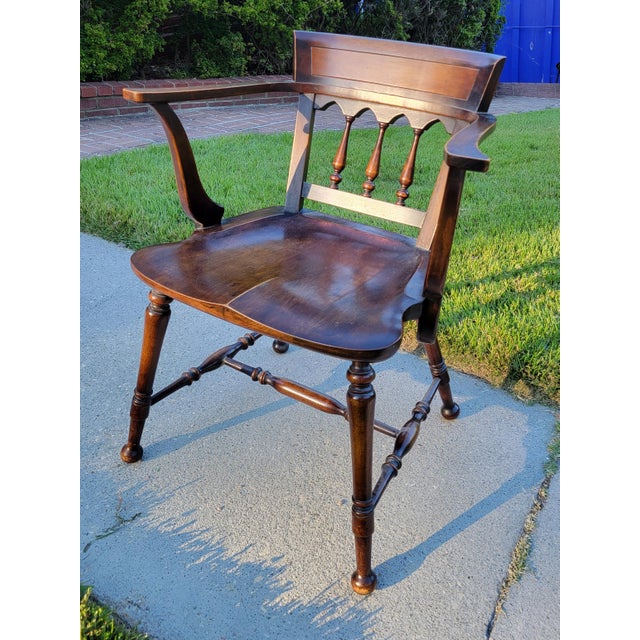 Made by Barber & Shanks Co. of Michigan, this Windsor arm chair features delicately turned legs, spindles, and stretchers;...