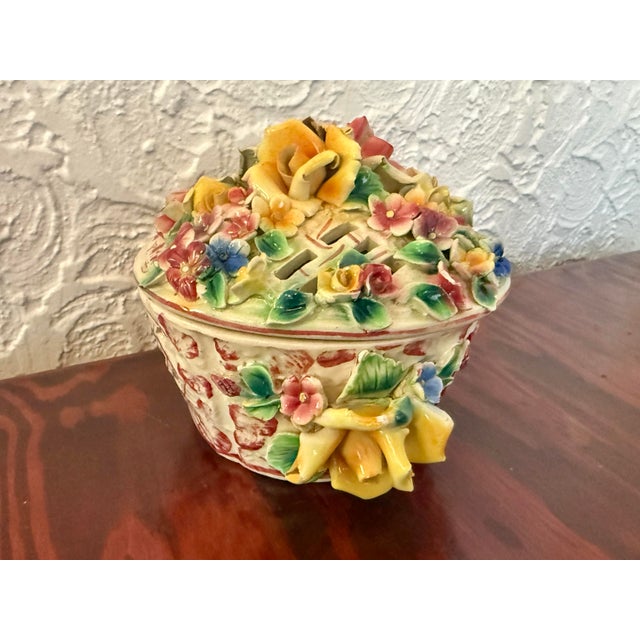 This Italian Capodimonte porcelain trinket box takes the form of a little flower basket, with hand-applied roses and...
