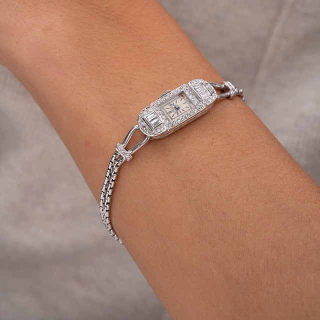 A refined Art Deco Gübelin Lucerne diamond wristwatch, exquisitely crafted in platinum and dating to the 1920s. This...