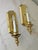 A pair of vintage French Provincial style electric wall sconces. The sconces feature a polished brass frame with a single...