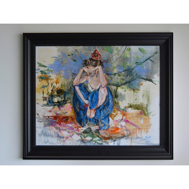 This painting depicts a figure seated in a moment of introspection, with their head bowed and arms wrapped around their...
