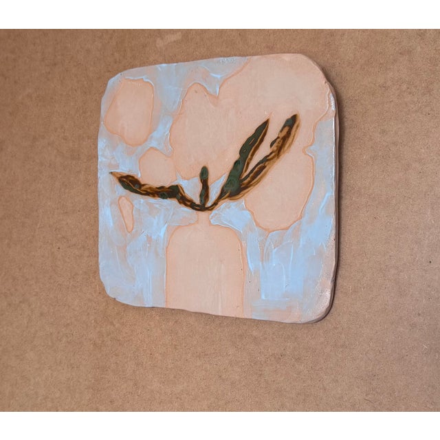 Handmade ceramic wall tile with hand-painted floral design. This decorative ceramic tile is finished with a smooth glazed...