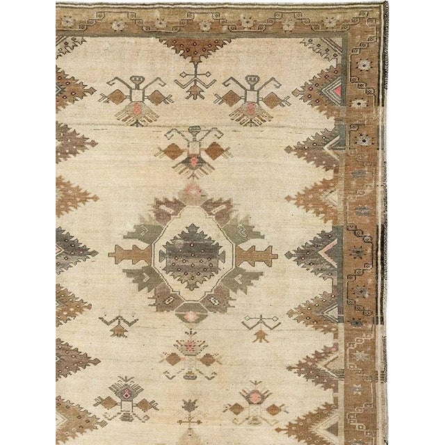 This Mid-20th century Turkish Anatolian room-size carpet presents a distinctive twin-panel composition arranged across a...
